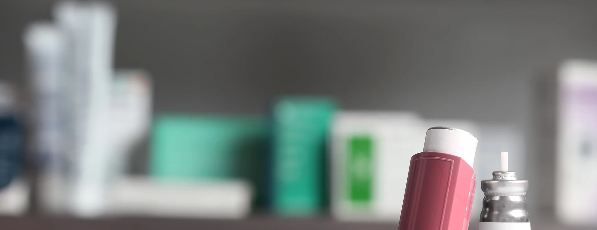 Asthma inhalers on table against blurred background. Space for text