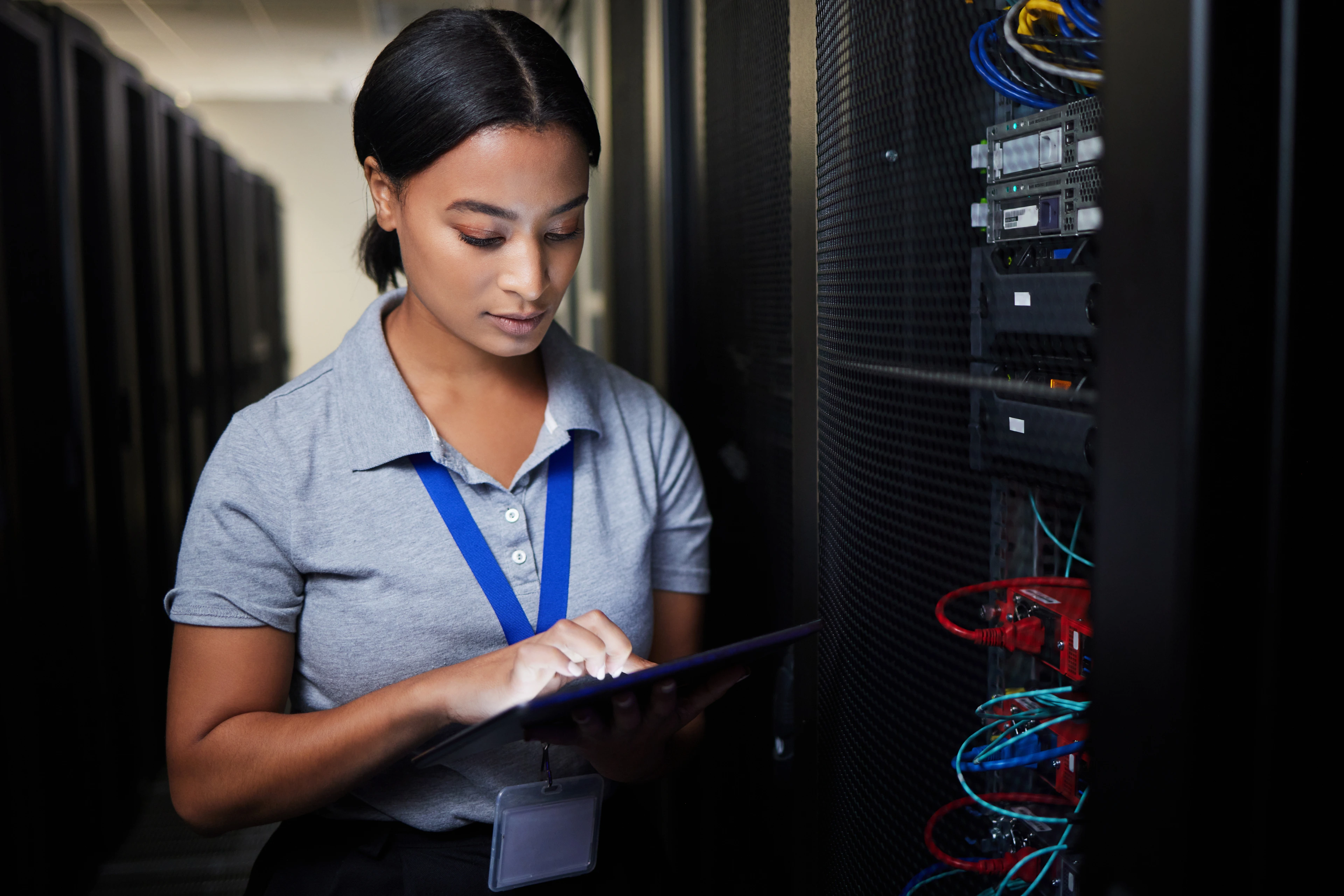 Woman, tablet and server room, programming or coding for cybersecurity, information technology or data protection backup. Engineering person on digital software, hardware inspection or basement check