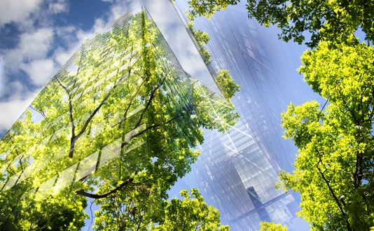 green city - double exposure of lush green forest and modern skyscrapers windowsg