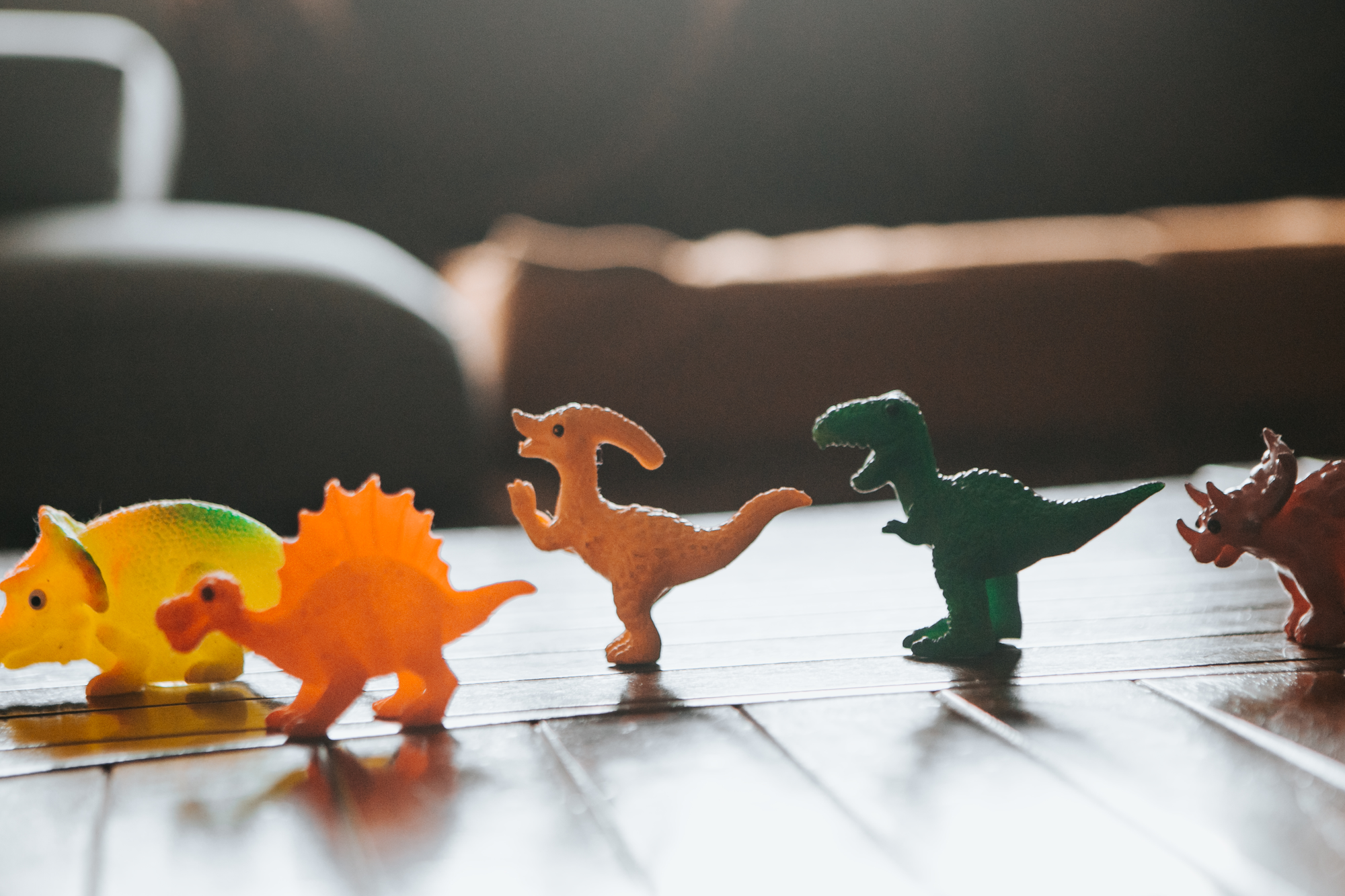 Mehrere Spielzeug-Dinosaurier auf einem Tisch.