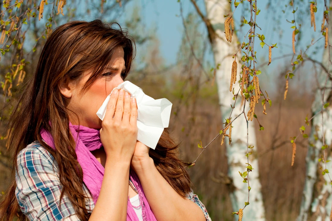 Frau putzt sich die Nase