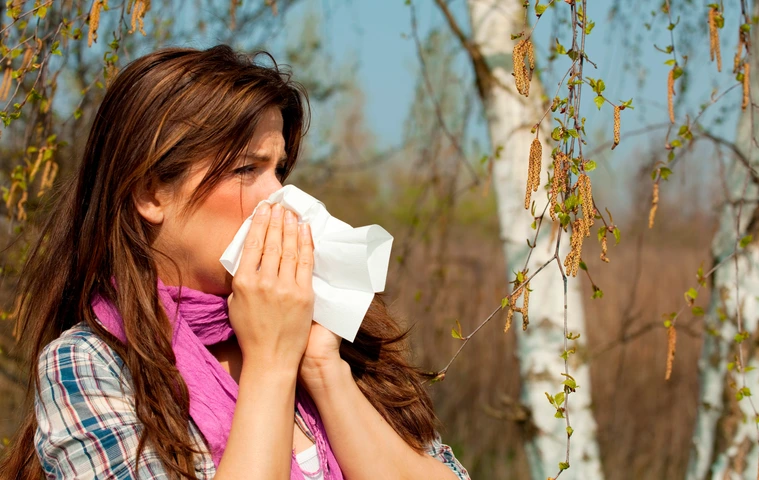 Frau hat Heuschnupfen gegen Birkenpollen