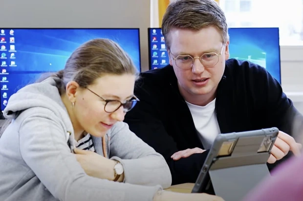 Steffen Schneider zeigt einer Schülerin wie man mit KI arbeiten kann