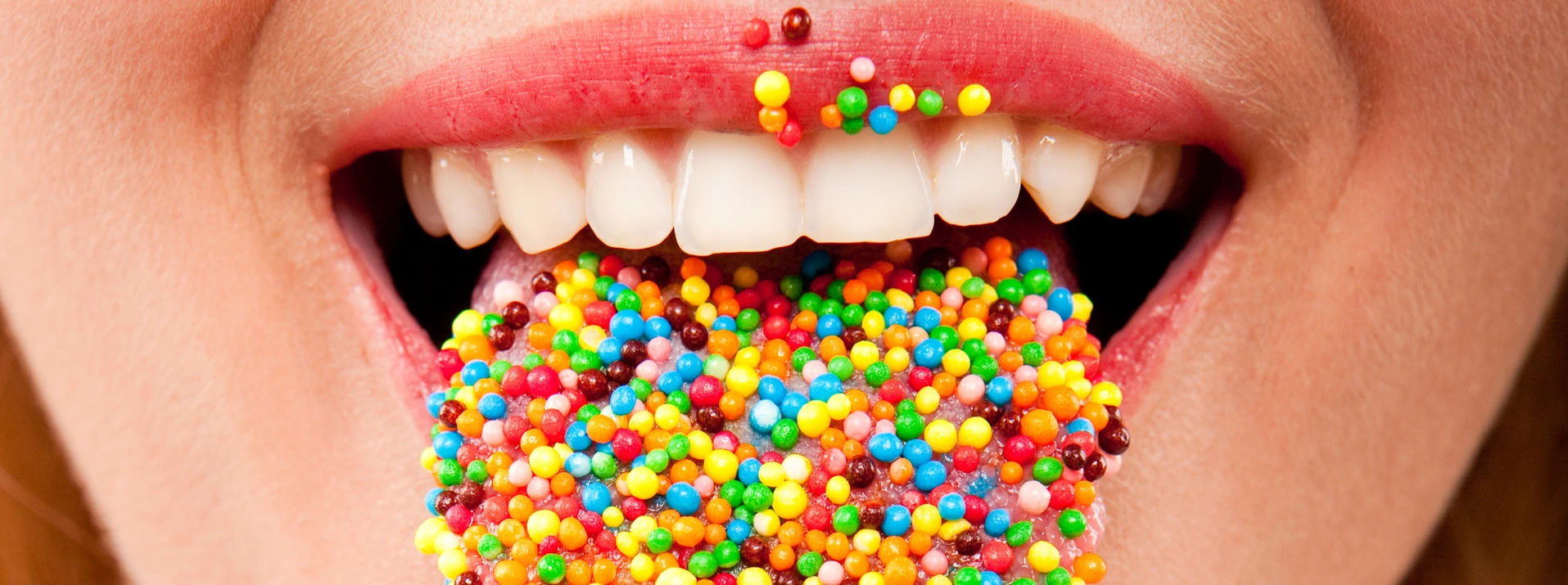 many color bright candies on female tongue