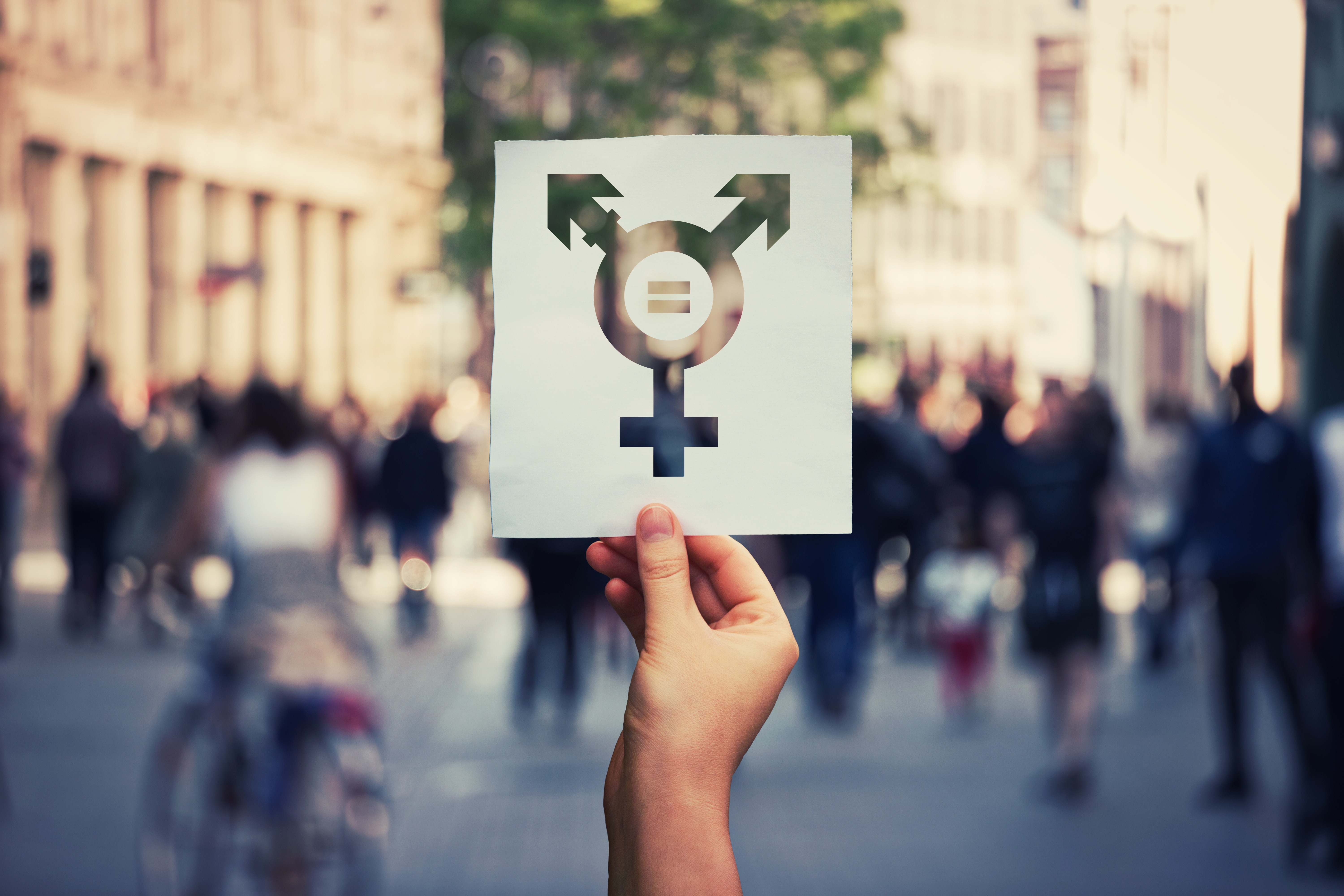 Hand holding a paper sheet with transgender symbol