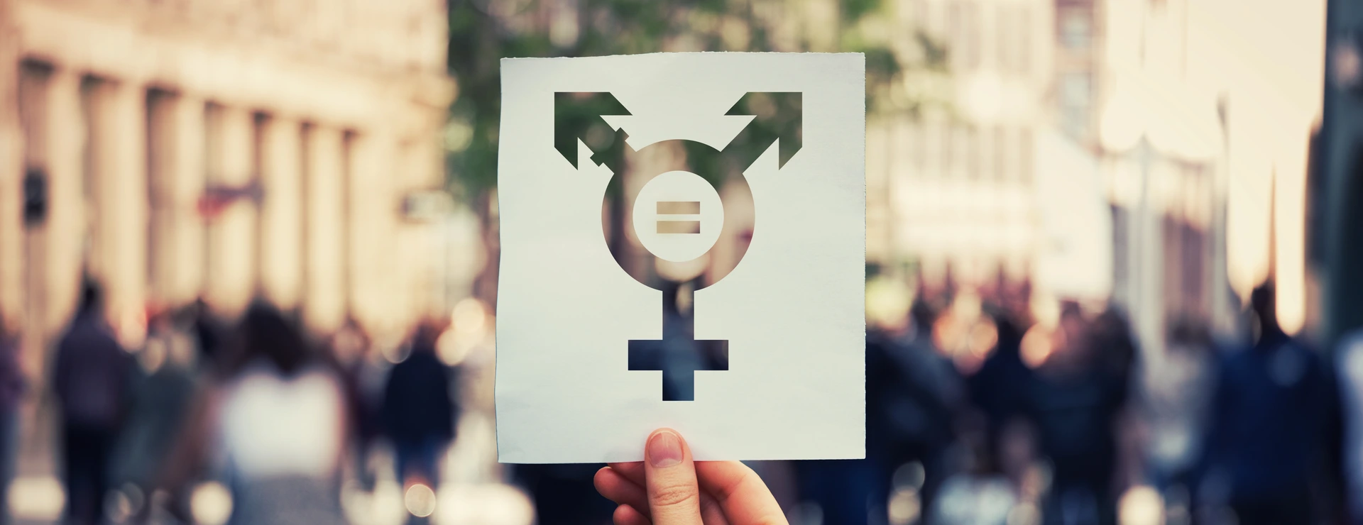 Hand holding a paper sheet with transgender symbol
