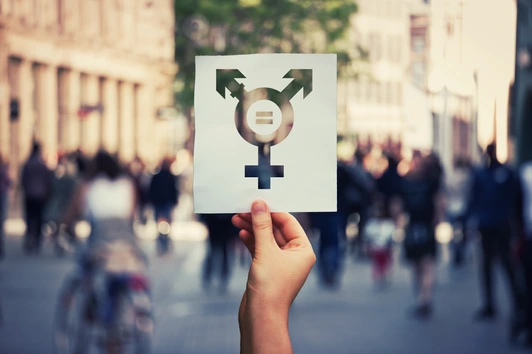 Hand holding a paper sheet with transgender symbol