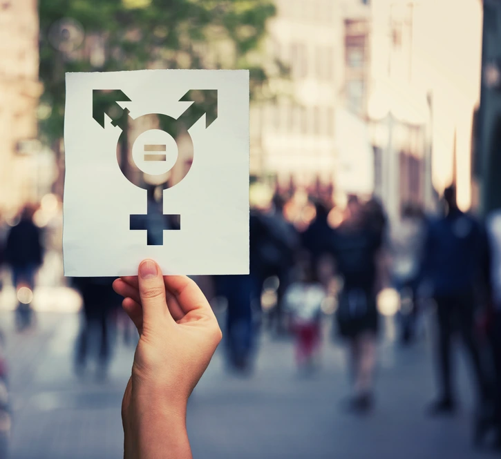 Hand holding a paper sheet with transgender symbol