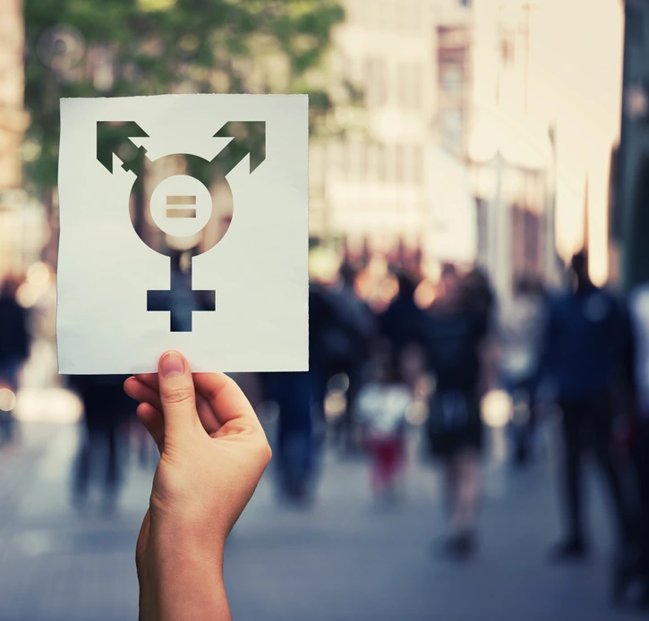 Hand holding a paper sheet with transgender symbol