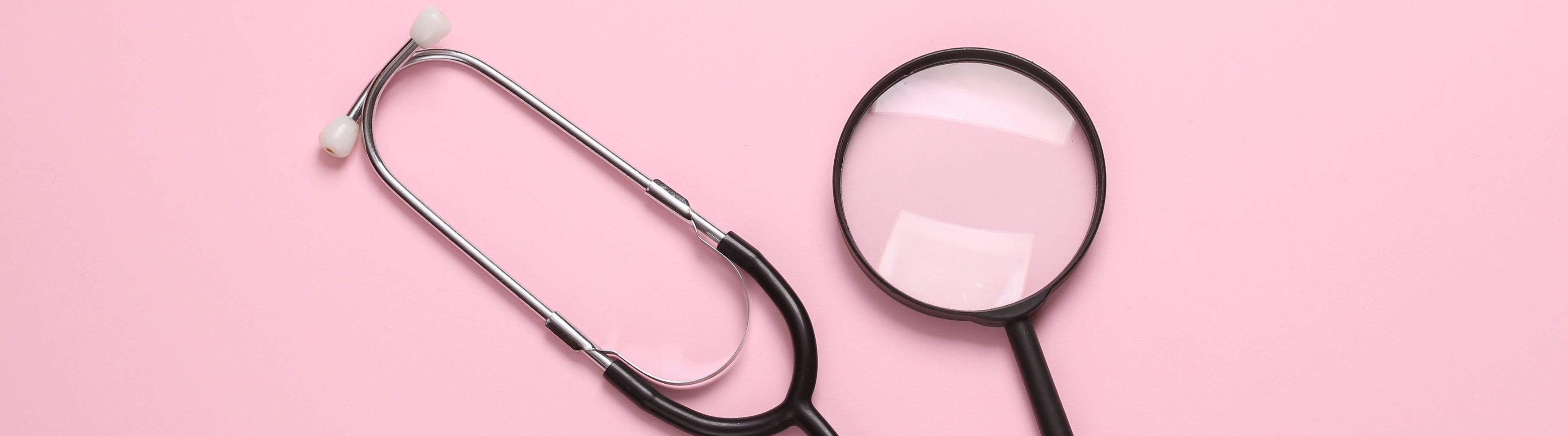 Stethoscope with magnifying glass on pink background. Diagnosis of diseases. Top view
