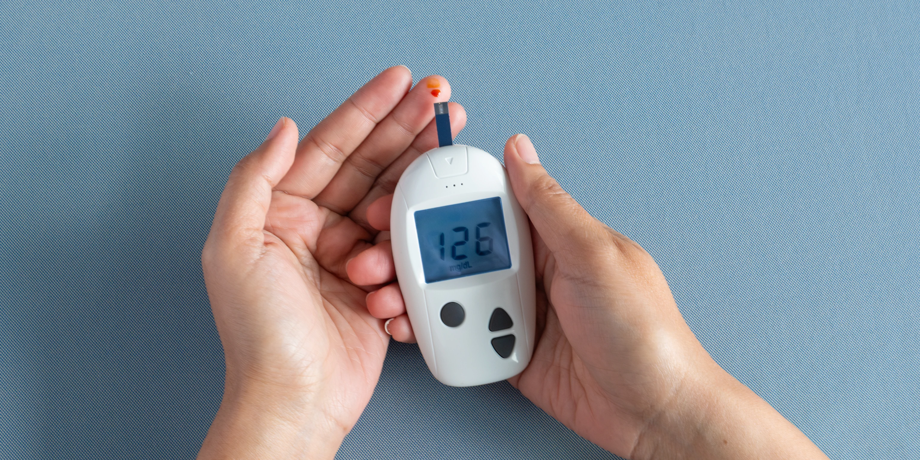 Woman's hands checking diabetes and hyperglycemia with digital blood sugar meter.