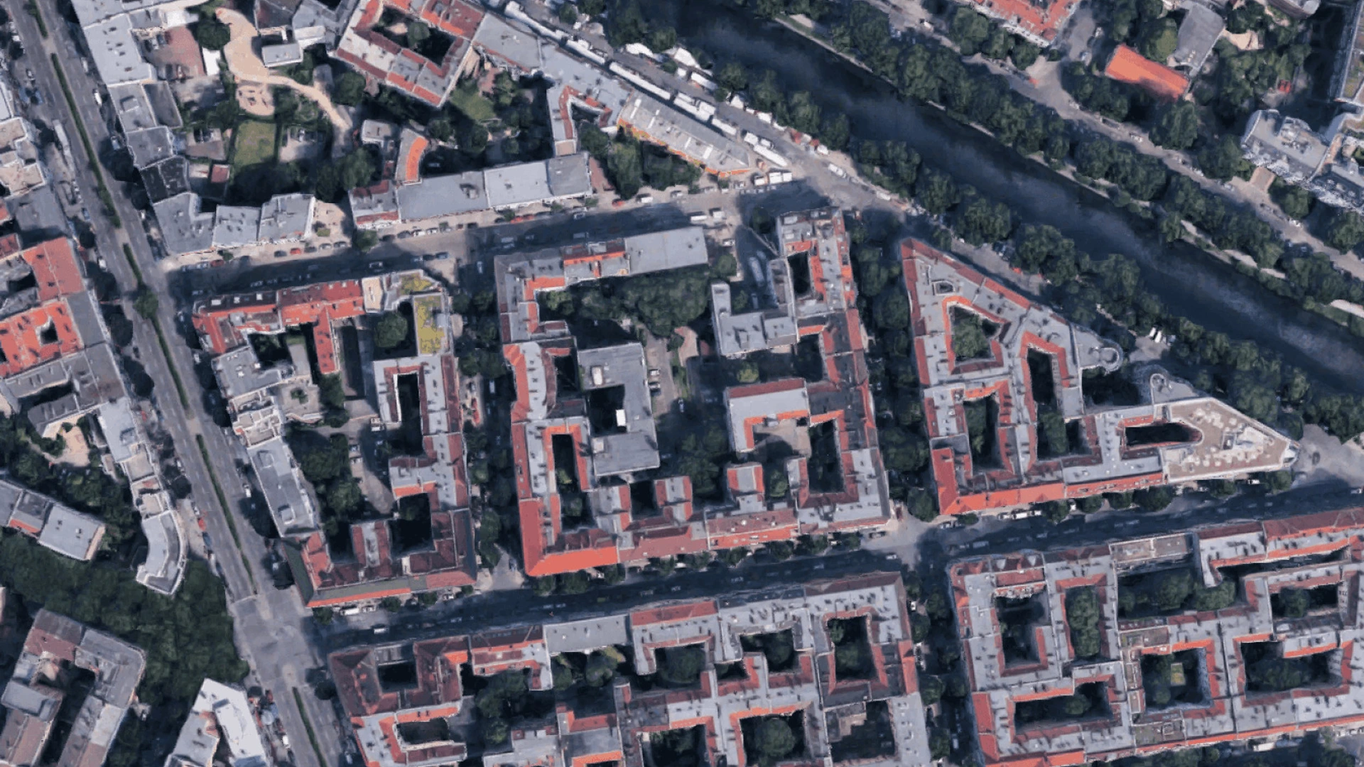 Luftaufnahme eines Wohnviertels mit roten Dächern, Innenhöfen und Fluss, PALMBERG