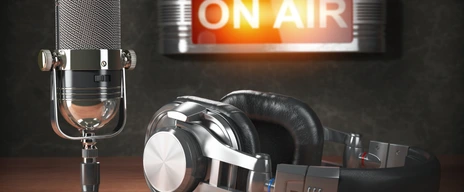 Vintage microphone  and headphones with signboard on air
