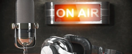Vintage microphone  and headphones with signboard on air