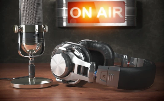 Vintage microphone  and headphones with signboard on air
