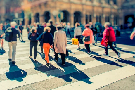 Crowd of anonymous people walking on busy city street