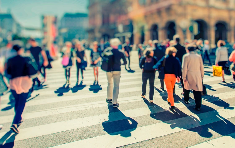 Crowd of anonymous people walking on busy city street