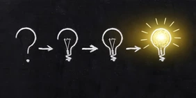 Black and white light bulb using doodle art on chalkboard background