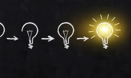 Black and white light bulb using doodle art on chalkboard background