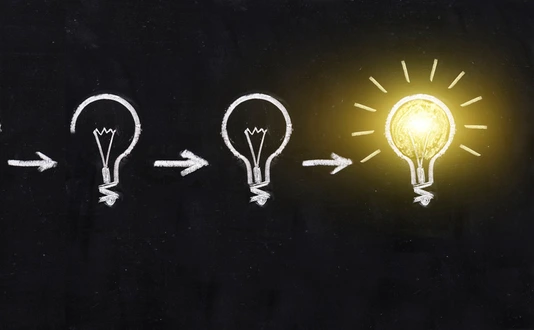 Black and white light bulb using doodle art on chalkboard background