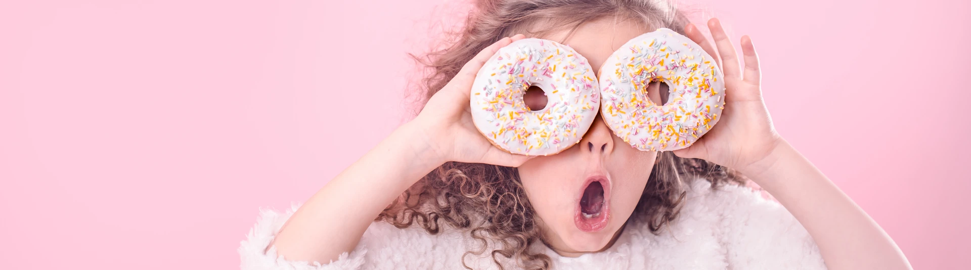 Portrait of a little surprised girl with donuts