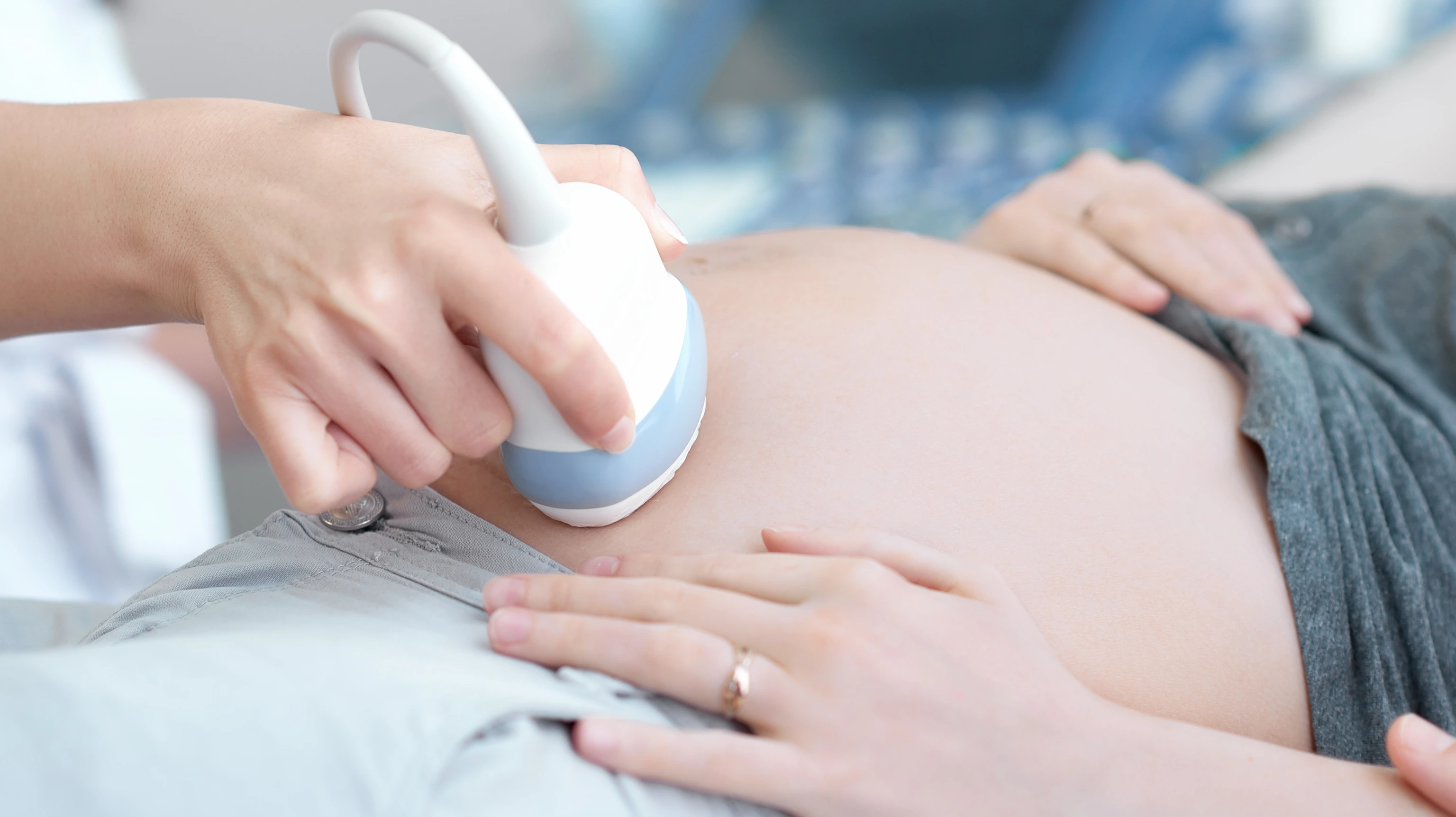 Doctor using ultrasound equipment screening of pregnant woman.
