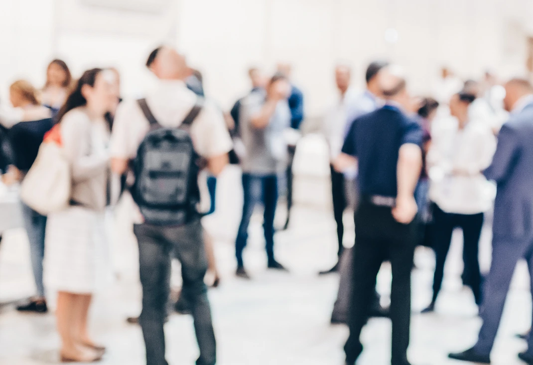 Abstract blurred people socializing during coffee break at business conference.