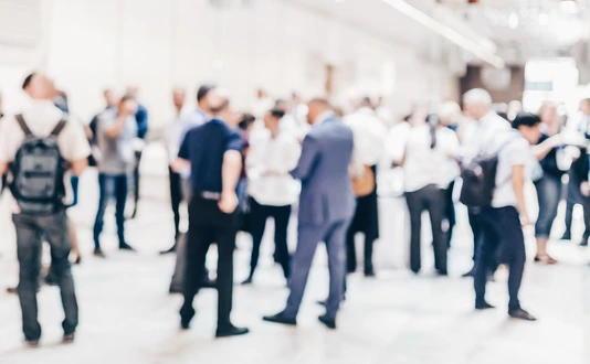 Abstract blurred people socializing during coffee break at business conference.