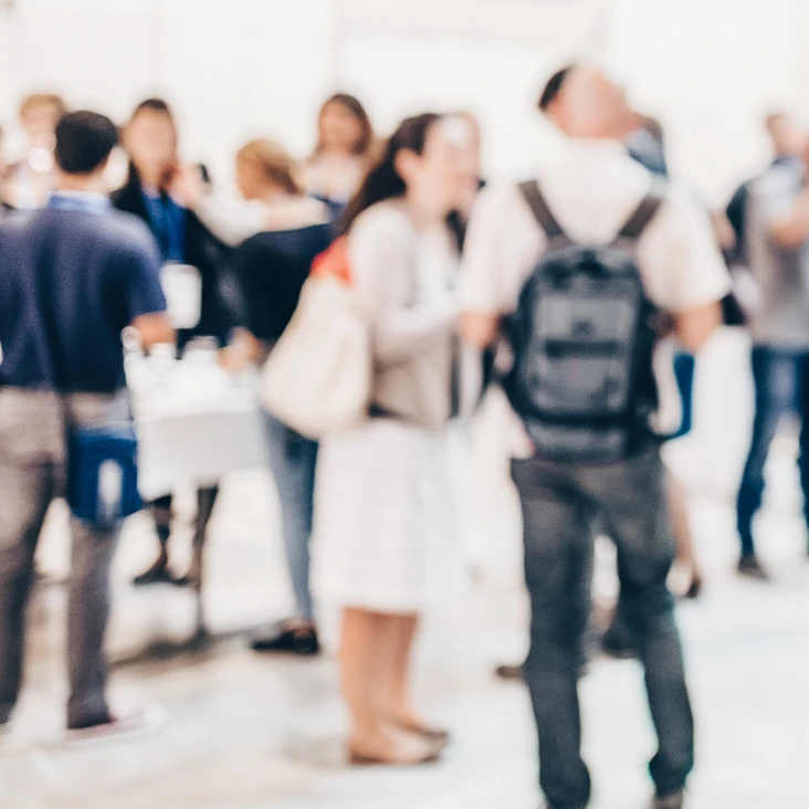 Abstract blurred people socializing during coffee break at business conference.