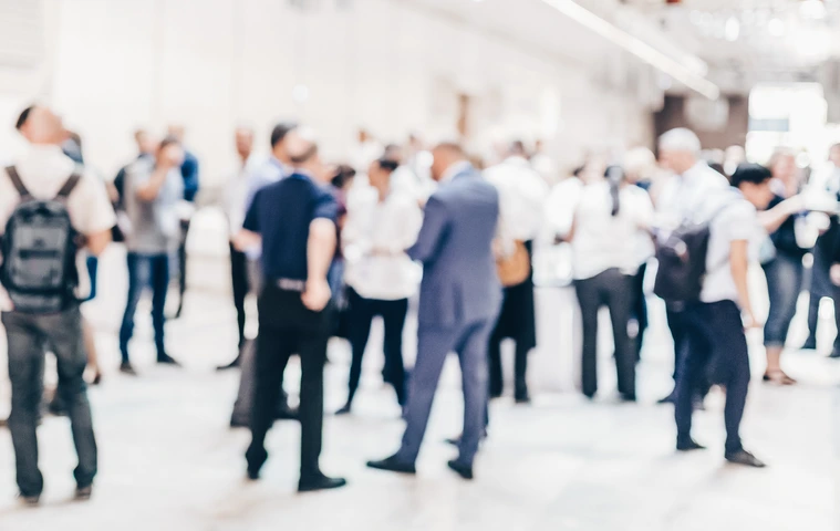 Abstract blurred people socializing during coffee break at business conference.
