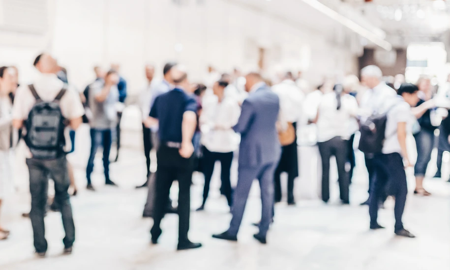 Abstract blurred people socializing during coffee break at business conference.