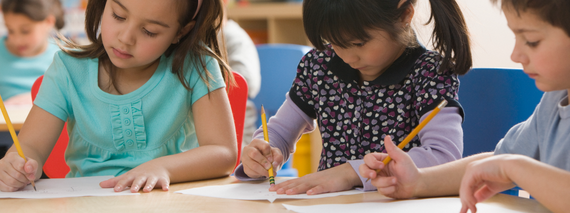 Kinder schreiben konzentriert im Klassenzimmer.