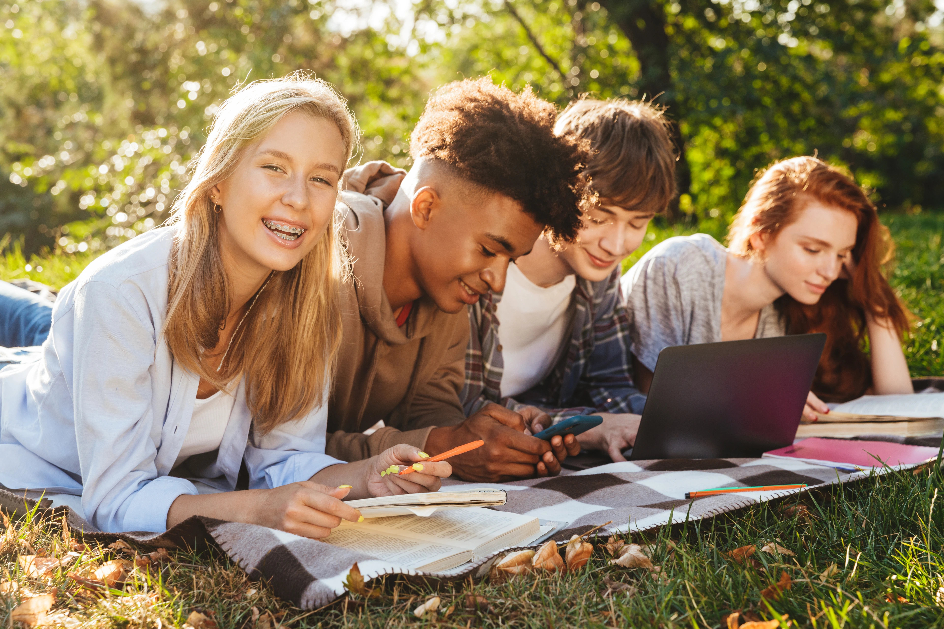 Group of excited multhiethnic students doing homework