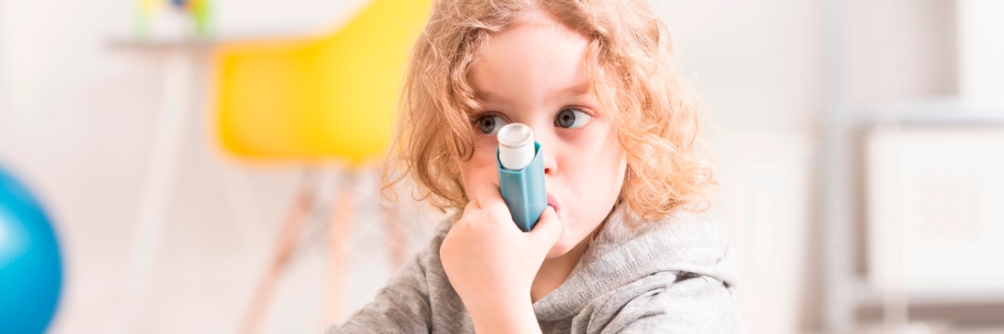 Kind inhaliert mit einem Asthma-Spray