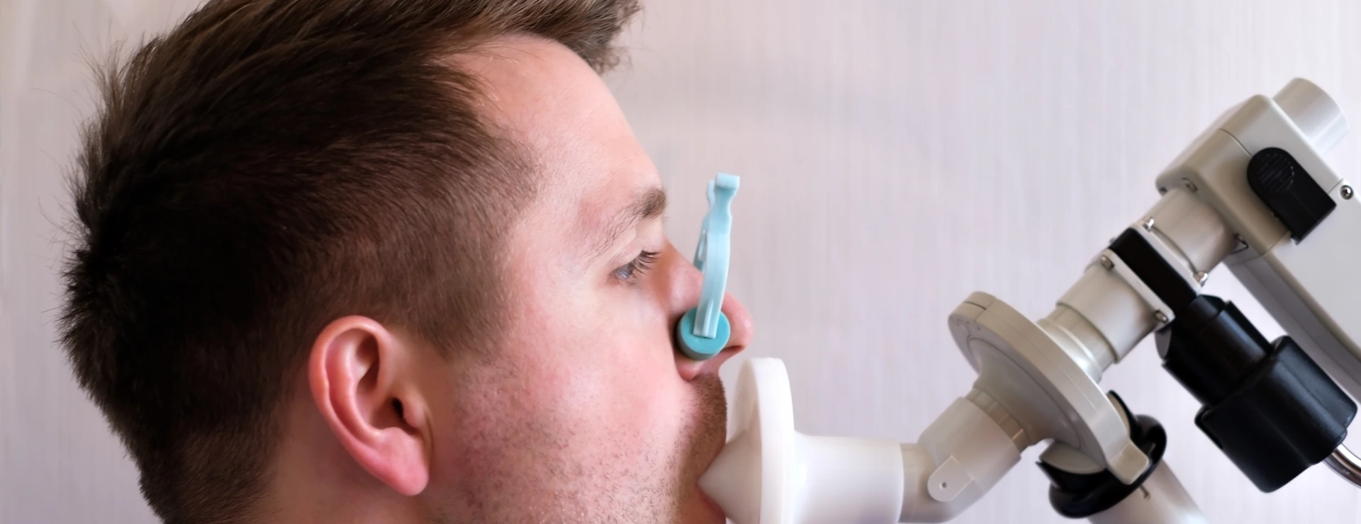 Young man testing breathing function by spirometry