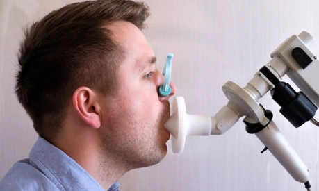 Young man testing breathing function by spirometry