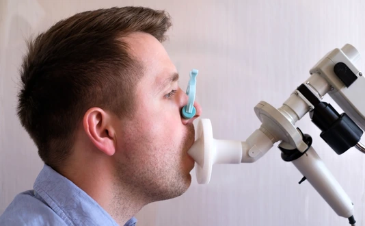 Young man testing breathing function by spirometry