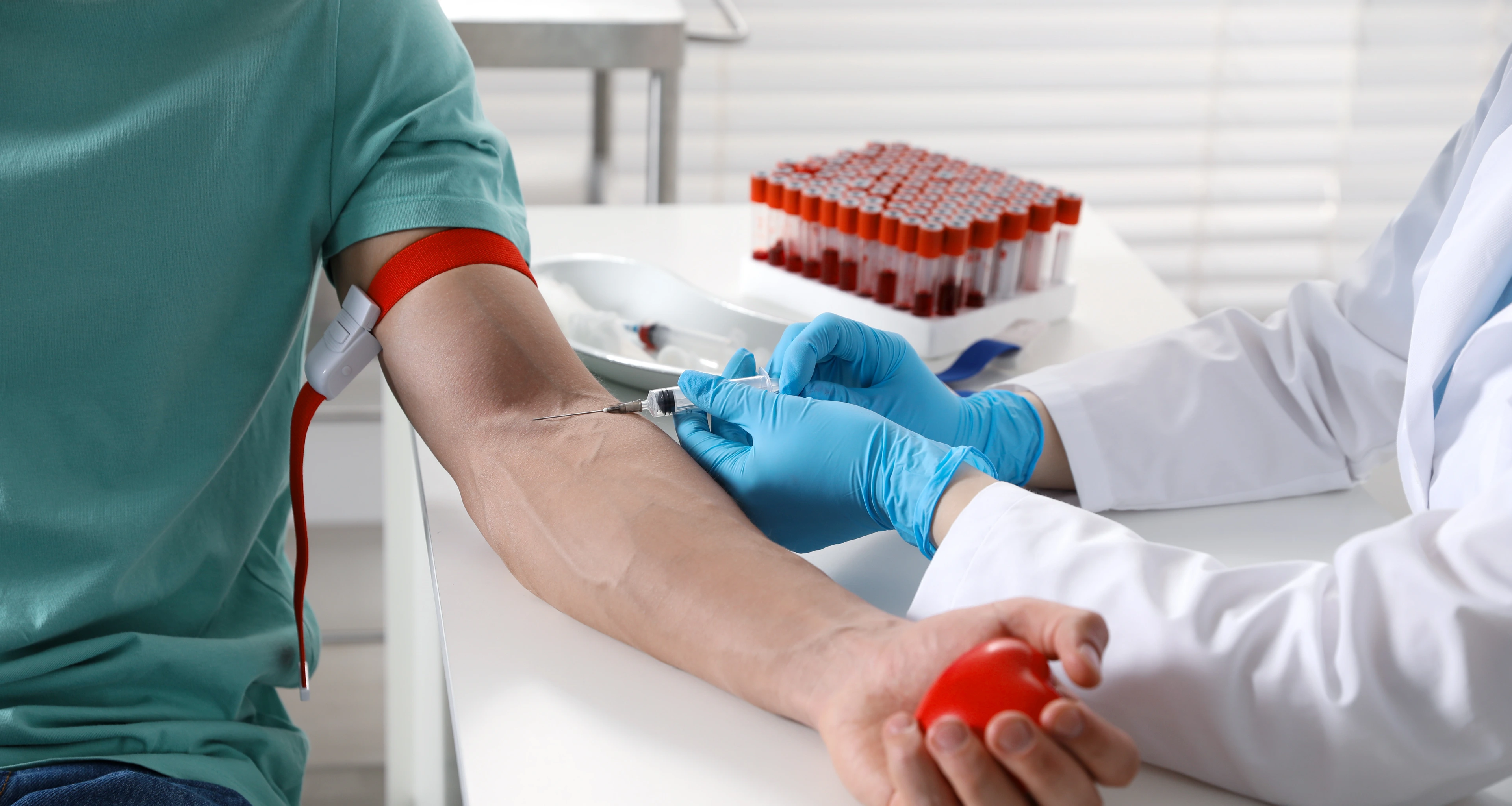 Doctor drawing man's blood sample in clinic, closeup  AdobeStock_1937412501