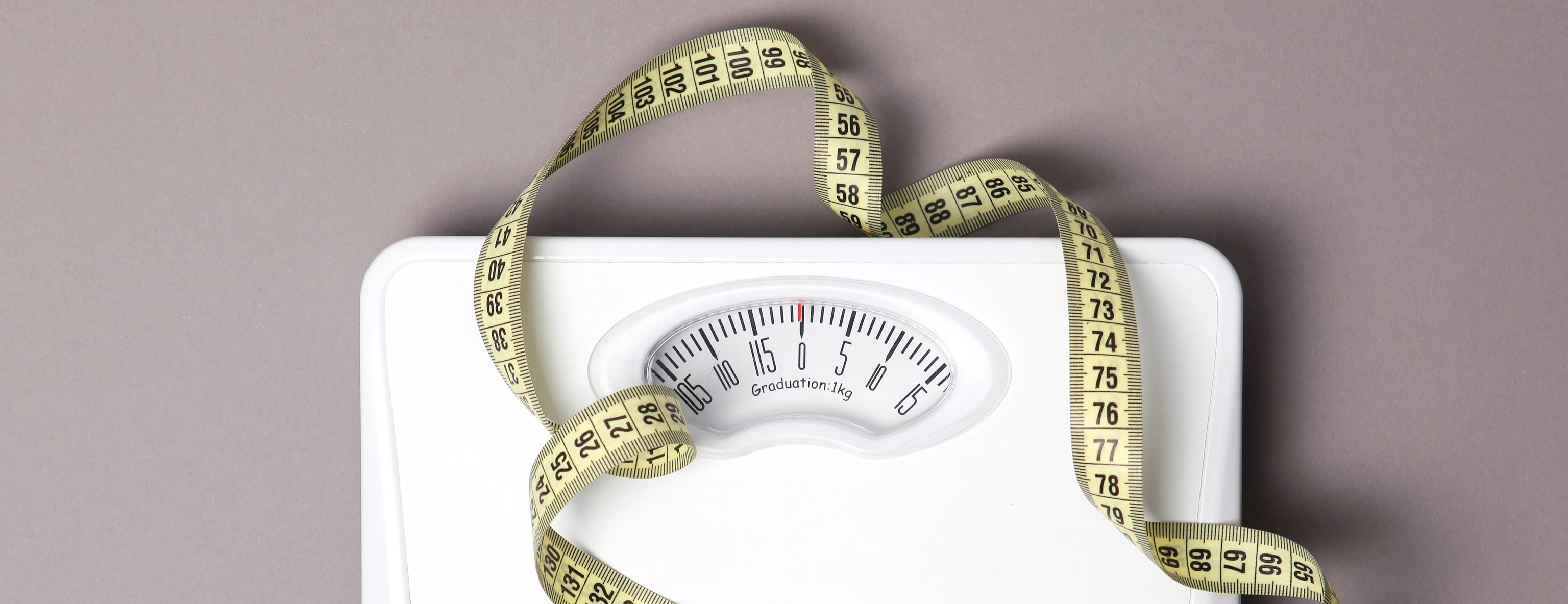floor scales and tape measure on a colored background top view. Healthy lifestyle concept, healthy eating. Body weight control.