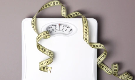 floor scales and tape measure on a colored background top view. Healthy lifestyle concept, healthy eating. Body weight control.