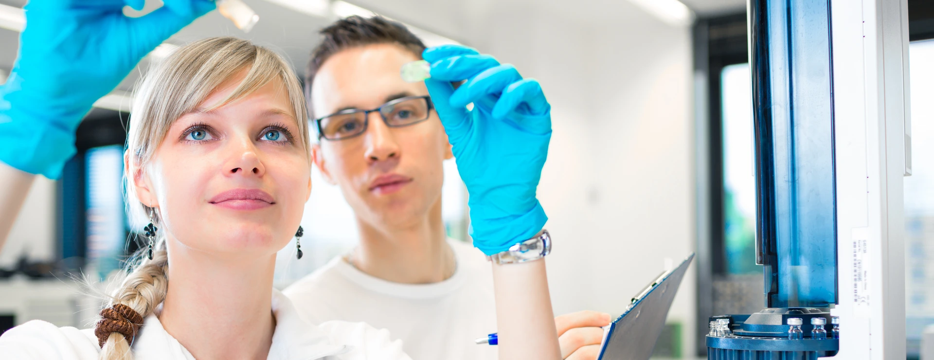 Two young researchers carrying out experiments in a lab (shallow DOF; color toned image)