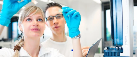 Two young researchers carrying out experiments in a lab (shallow DOF; color toned image)