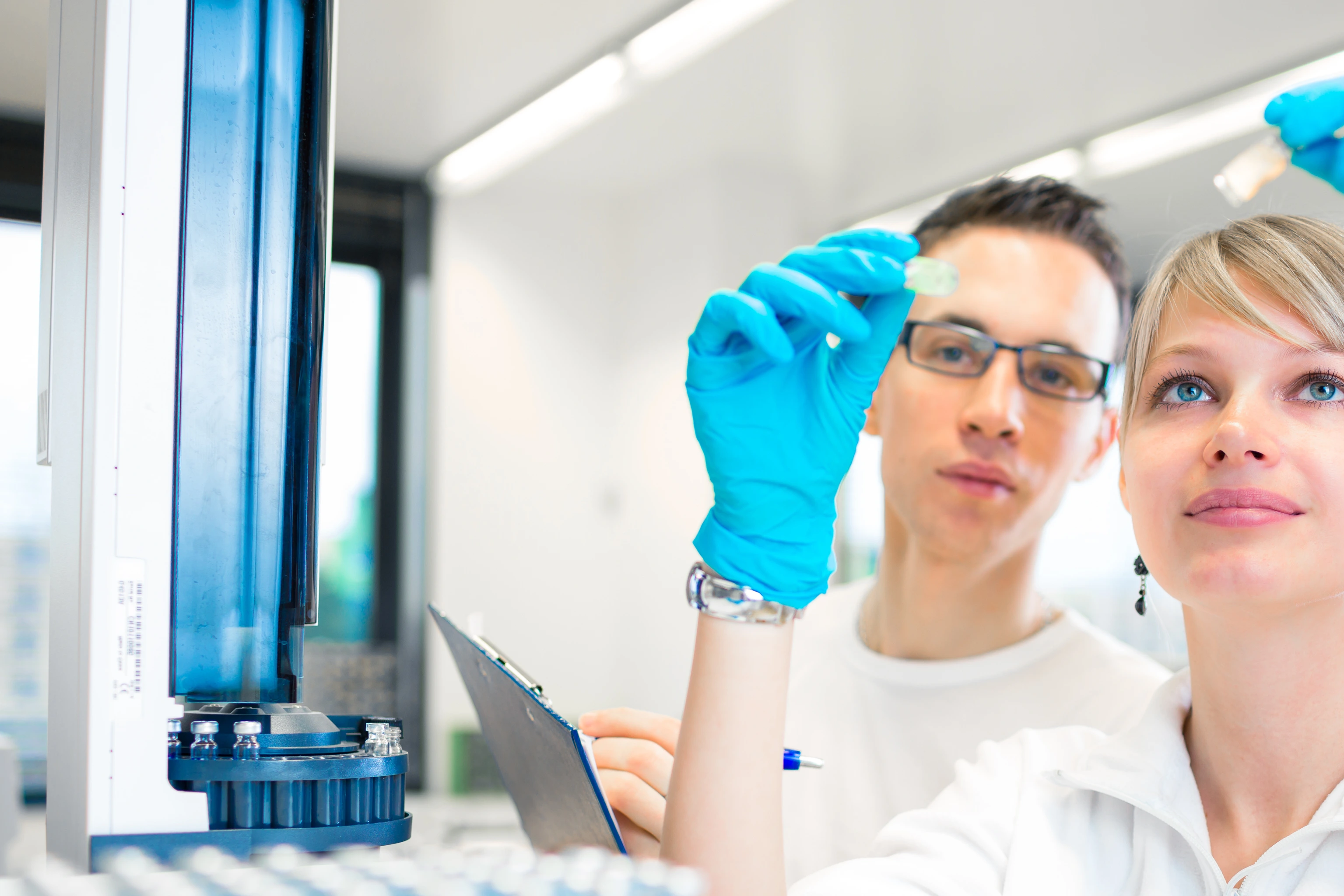 Two young researchers carrying out experiments in a lab (shallow DOF; color toned image)