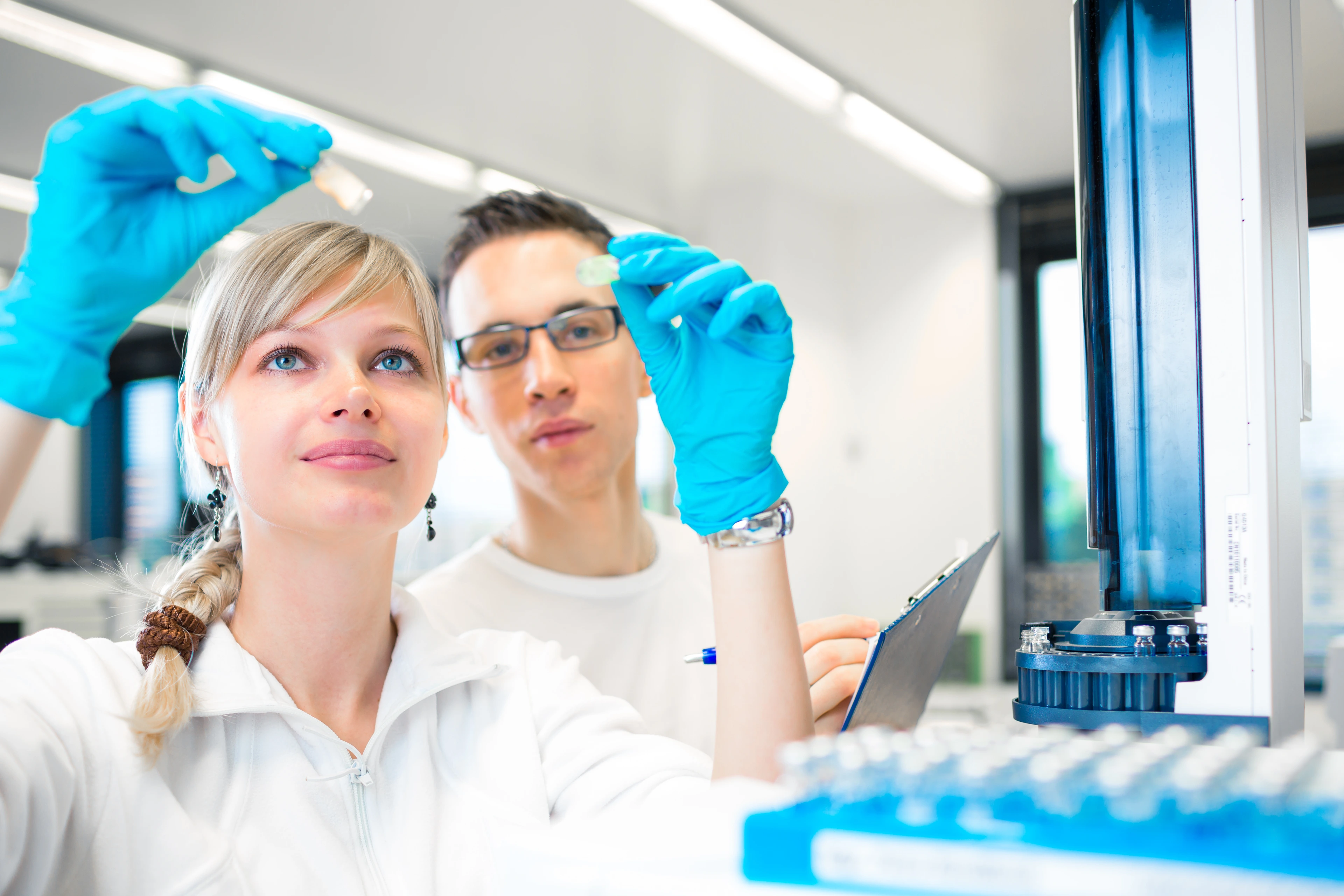 Two young researchers carrying out experiments in a lab (shallow DOF; color toned image)