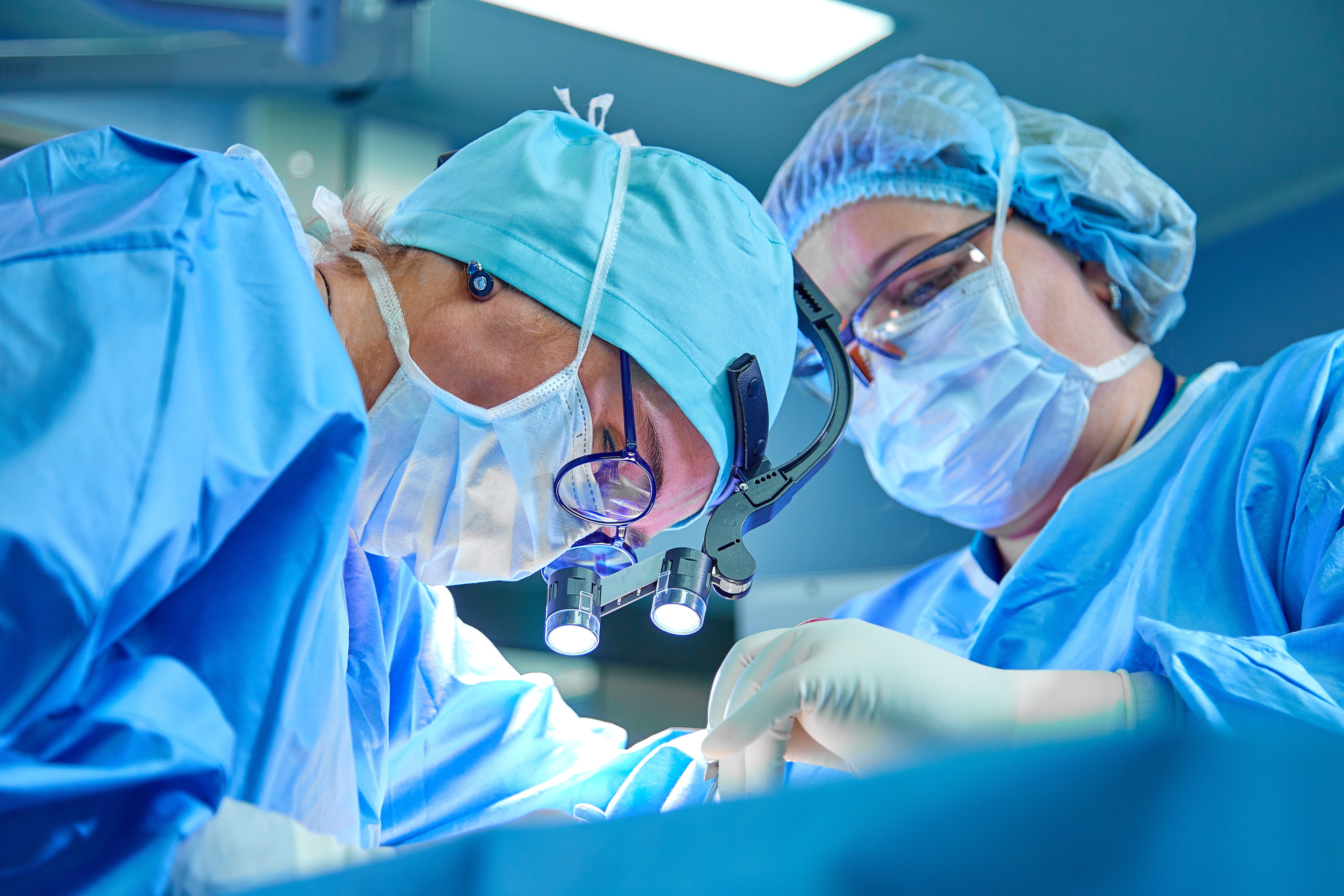 A surgeon's team in uniform performs an operation on a patient at a cardiac surgery clinic. Modern medicine, a professional team of surgeons, health.