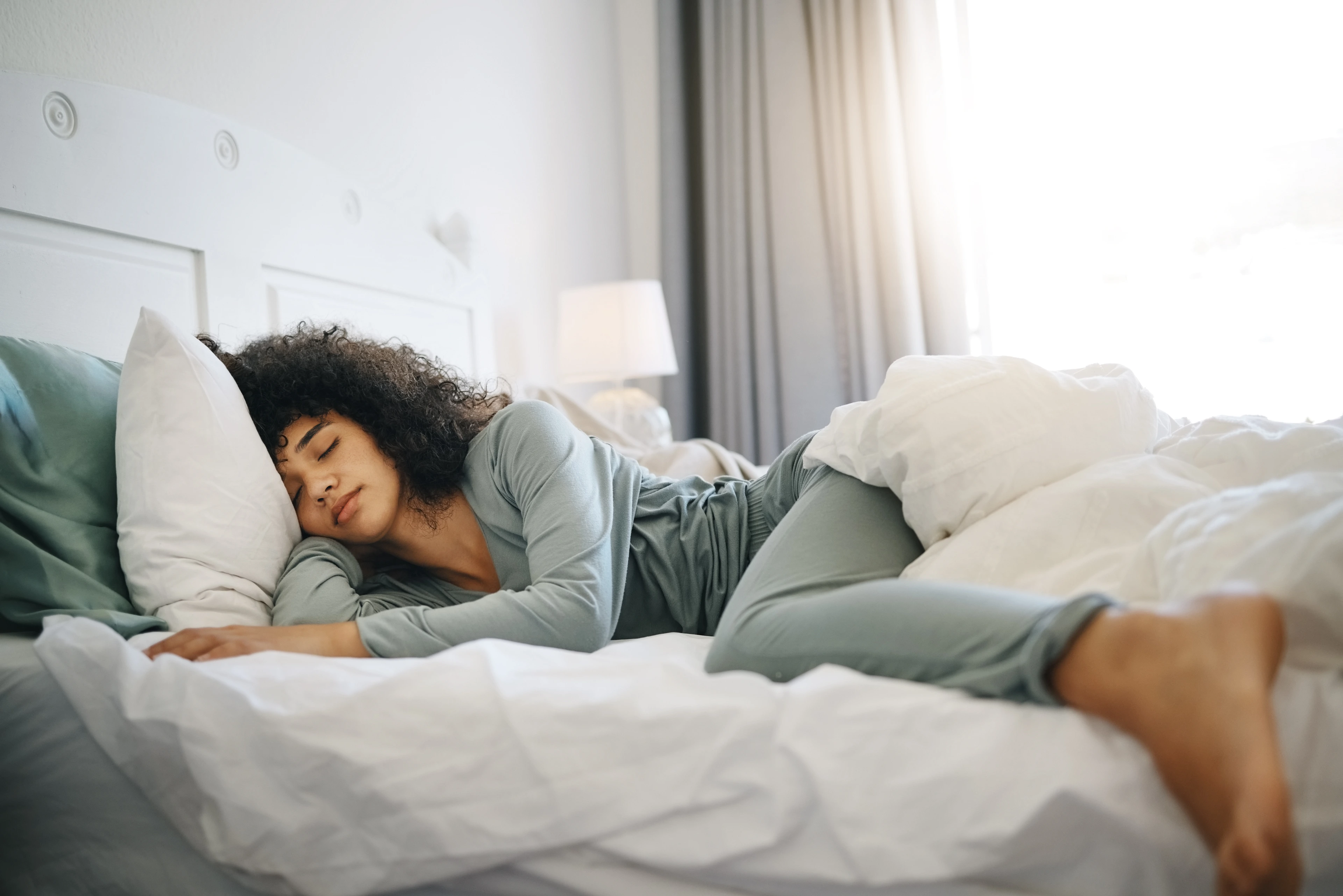 Eine Frau schläft tagsüber in ihrem Bett.