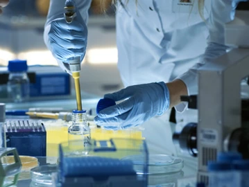 Female Research Scientist Uses Micropipette Filling Test Tubes. Scientist Works in a Team of Scientists Trying to Cure Deadly Disease, They Work in a Big Laboratory/ Research Center.