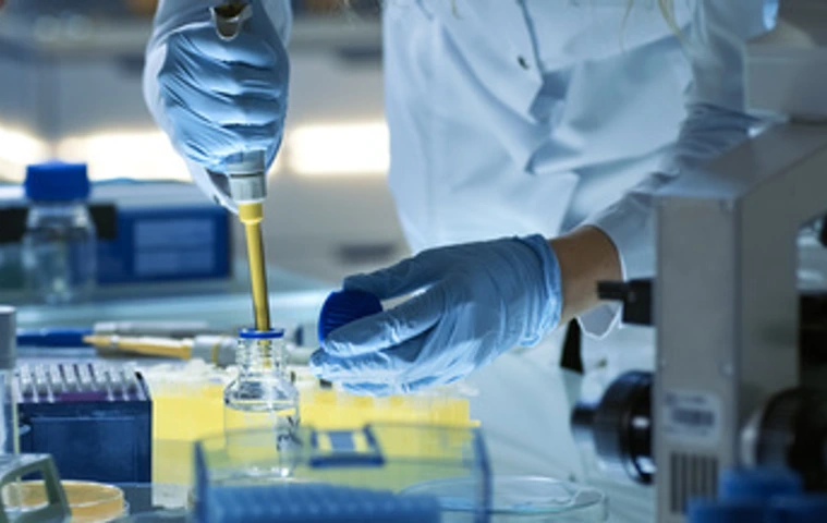 Female Research Scientist Uses Micropipette Filling Test Tubes. Scientist Works in a Team of Scientists Trying to Cure Deadly Disease, They Work in a Big Laboratory/ Research Center.