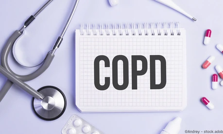 The word copd written on a white notepad on a blue background near a stethoscope, syringe, electronic thermometer and pills. Medical concept
