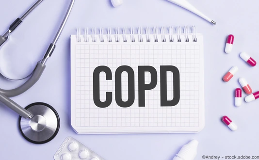 The word copd written on a white notepad on a blue background near a stethoscope, syringe, electronic thermometer and pills. Medical concept
